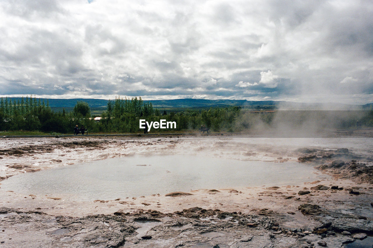 Scenic view of geyser against sky