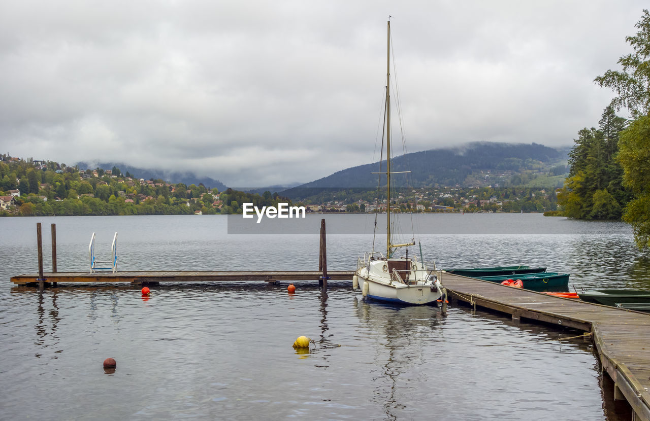 SAILBOATS IN LAKE AGAINST SKY