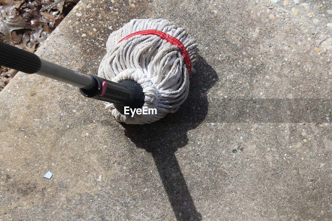 High angle view of mop on footpath during sunny day