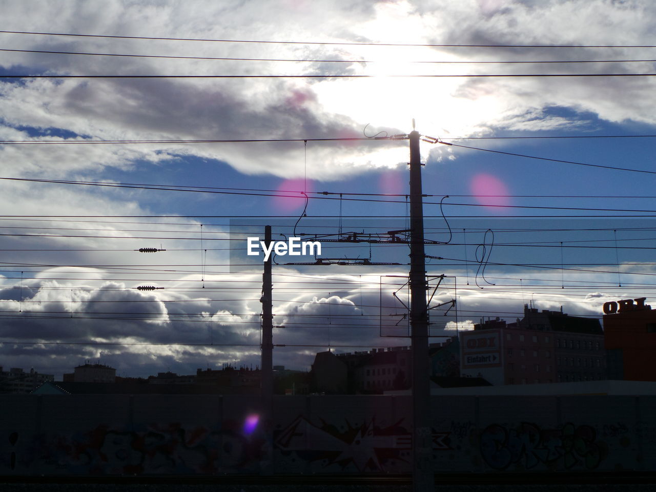 LOW ANGLE VIEW OF POWER LINES AGAINST CLOUDY SKY