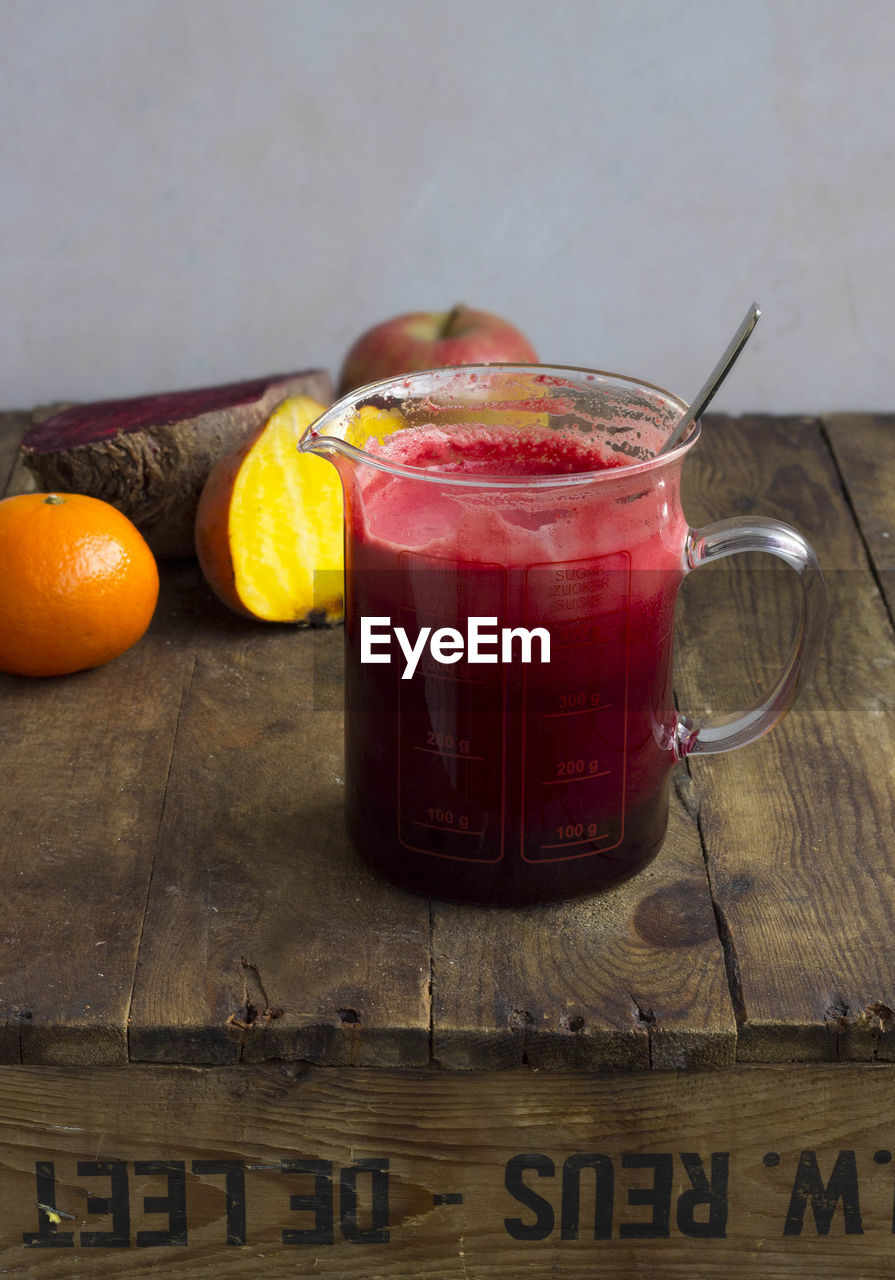 View of raw vegetable and fruit juice in measuring jug