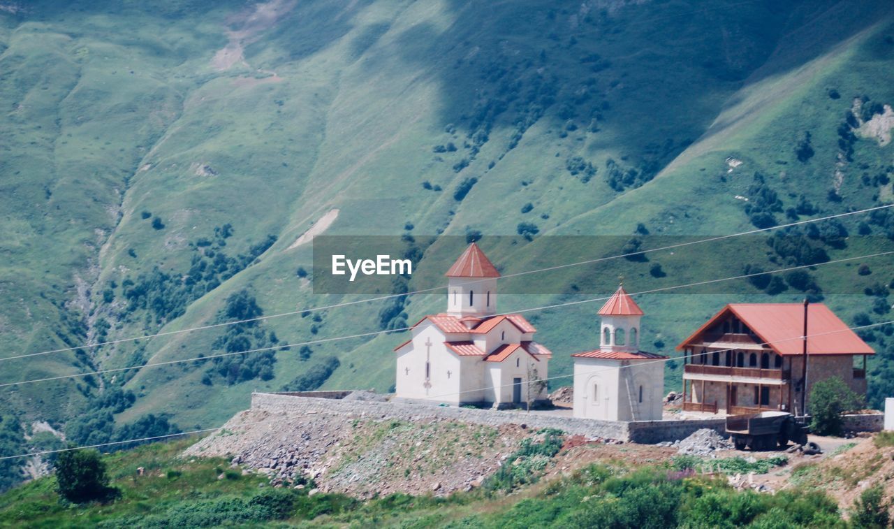 HOUSES ON MOUNTAIN AGAINST SKY