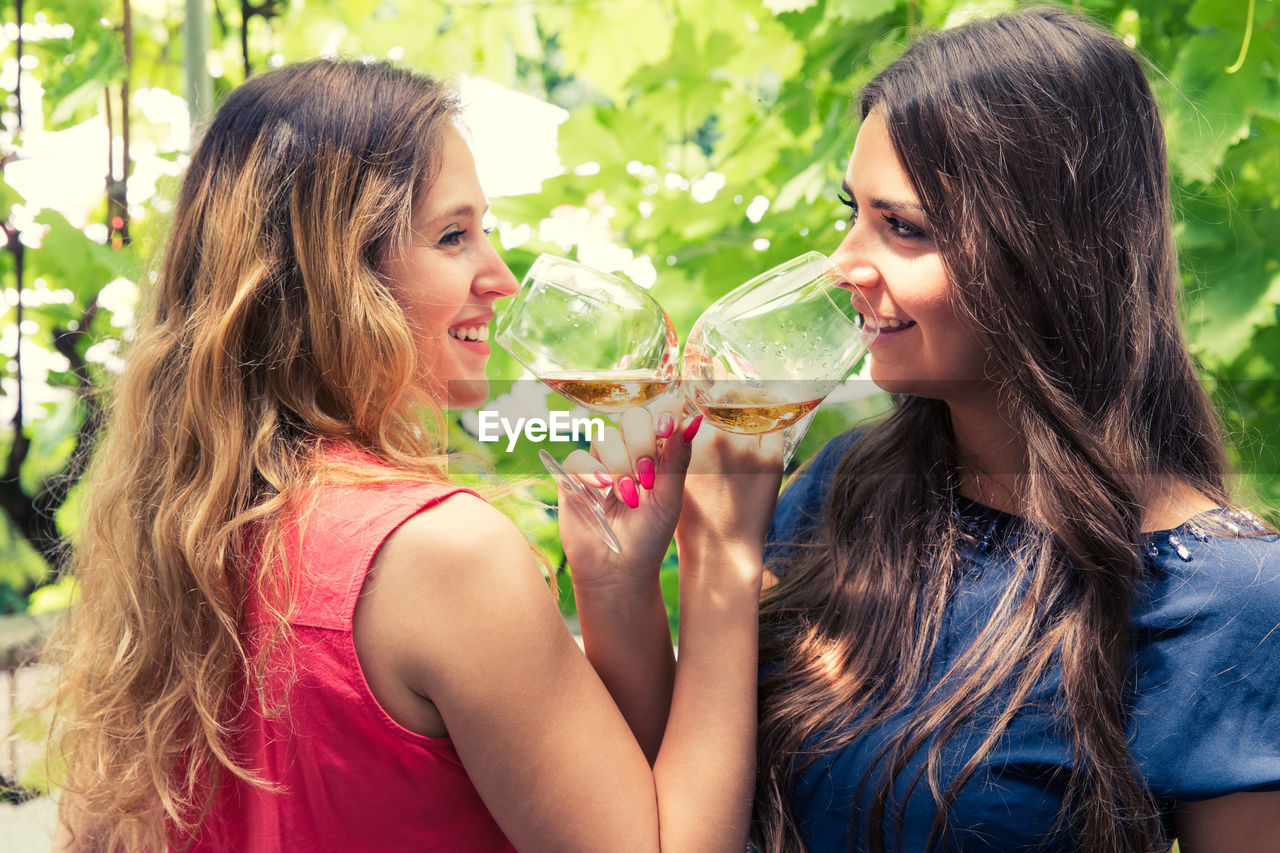 PORTRAIT OF BEAUTIFUL YOUNG WOMAN DRINKING WATER FROM OUTDOORS