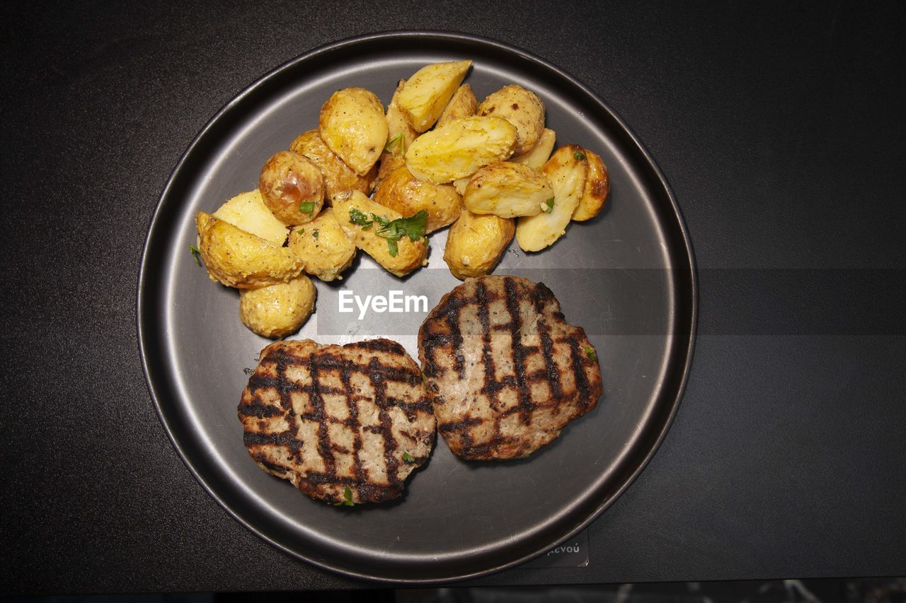 food, food and drink, fast food, freshness, indoors, meal, dish, snack, directly above, healthy eating, no people, breakfast, raw potato, fried, produce, studio shot, plate, still life, high angle view, wellbeing, black background, meat