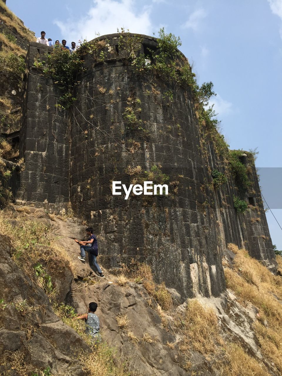 LOW ANGLE VIEW OF MAN AGAINST MOUNTAIN