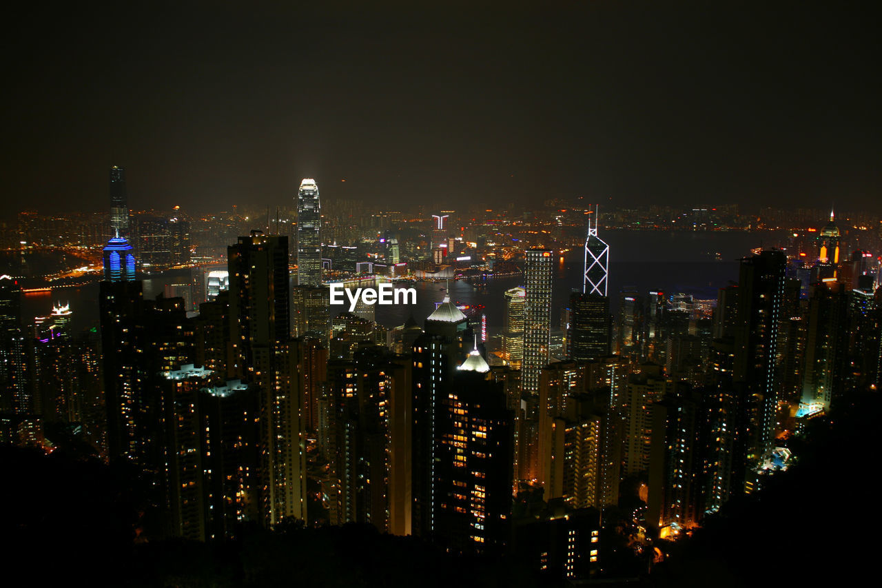 Illuminated cityscape against sky at night