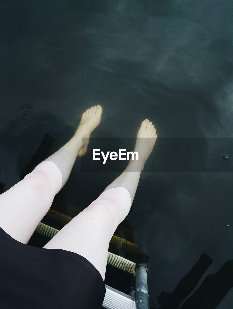 Low section of woman legs in water