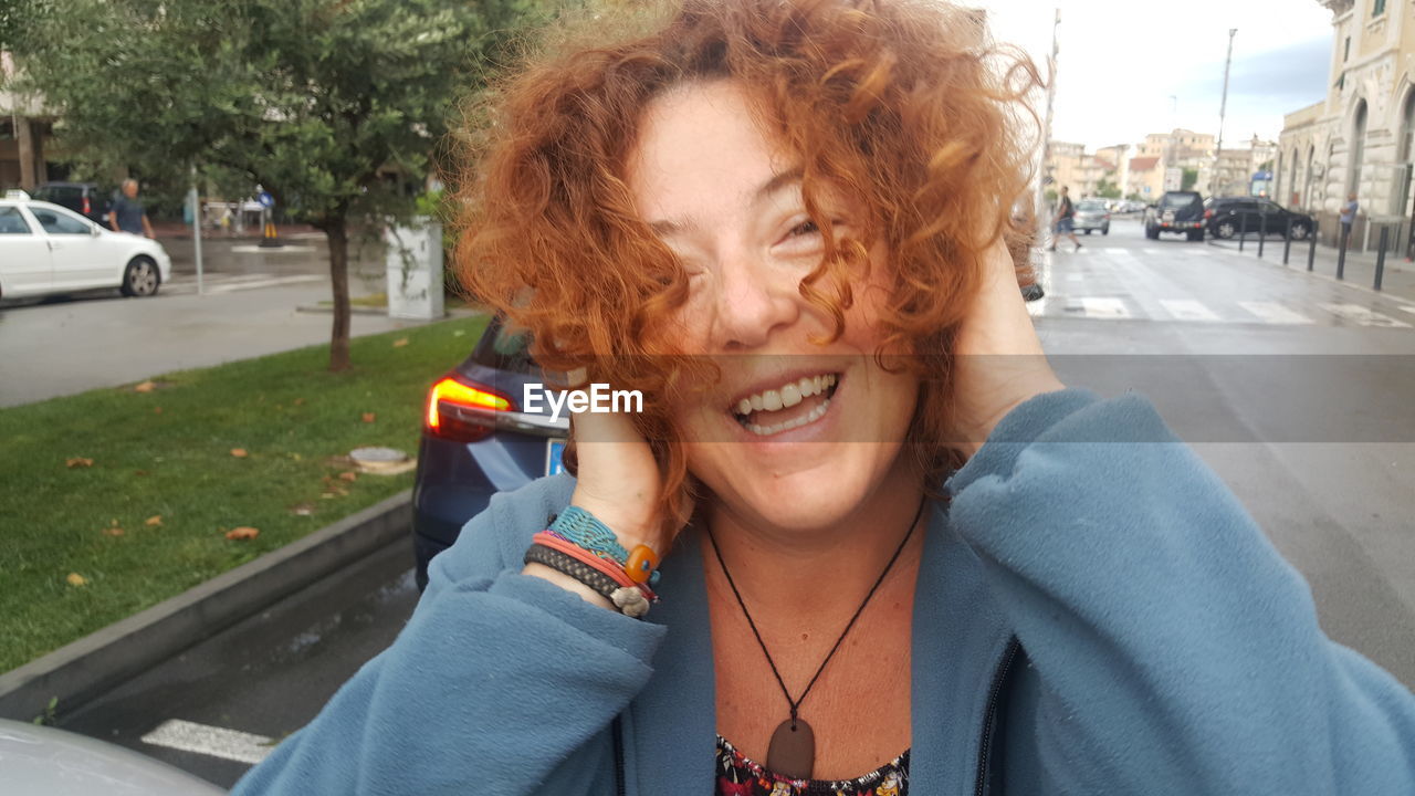 Portrait of smiling woman with hand in hair