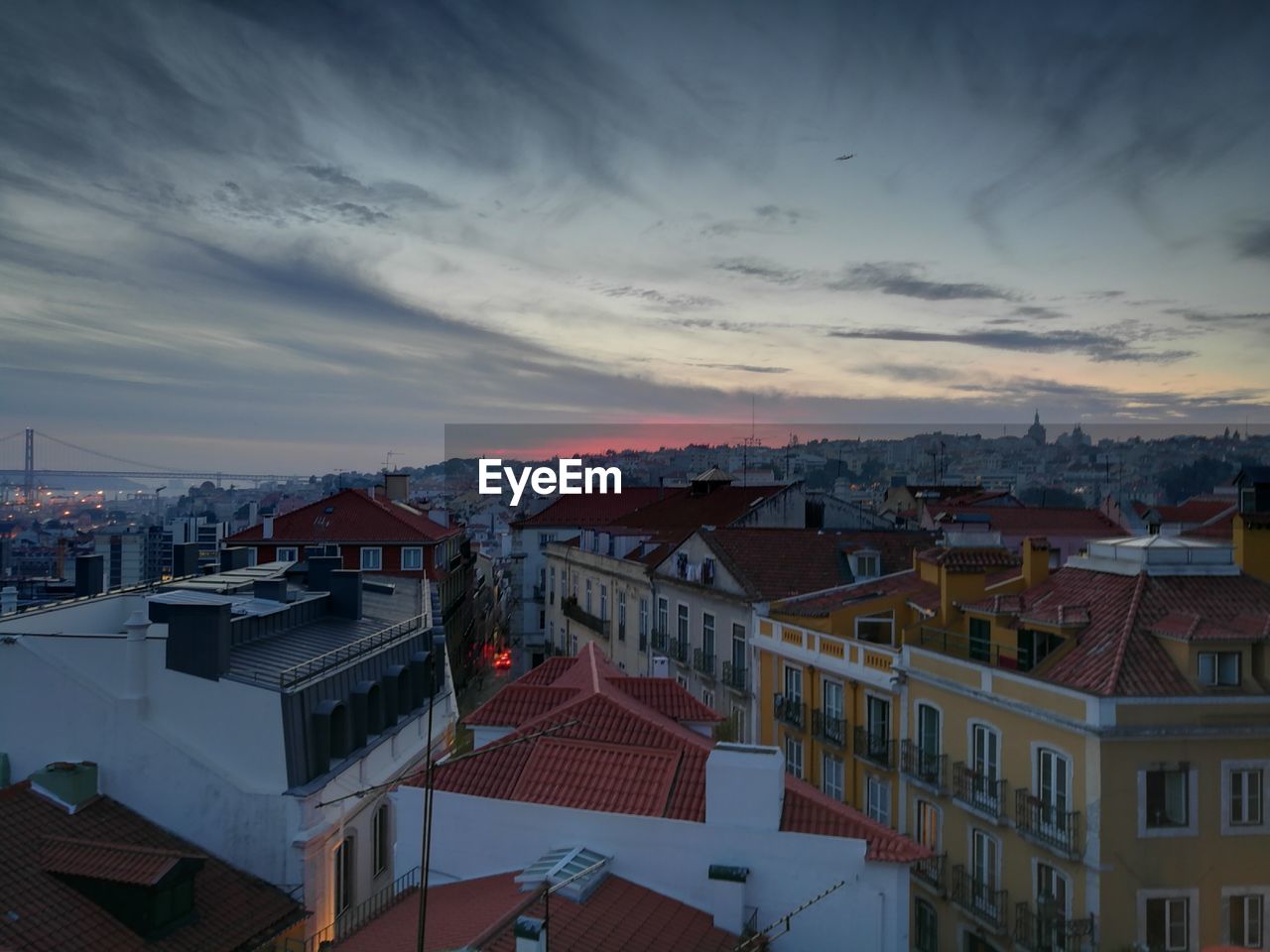 HIGH ANGLE VIEW OF TOWN AGAINST CLOUDY SKY