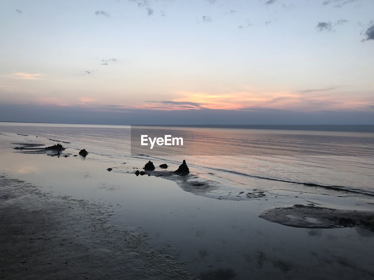 SCENIC VIEW OF BEACH AGAINST SKY DURING SUNSET