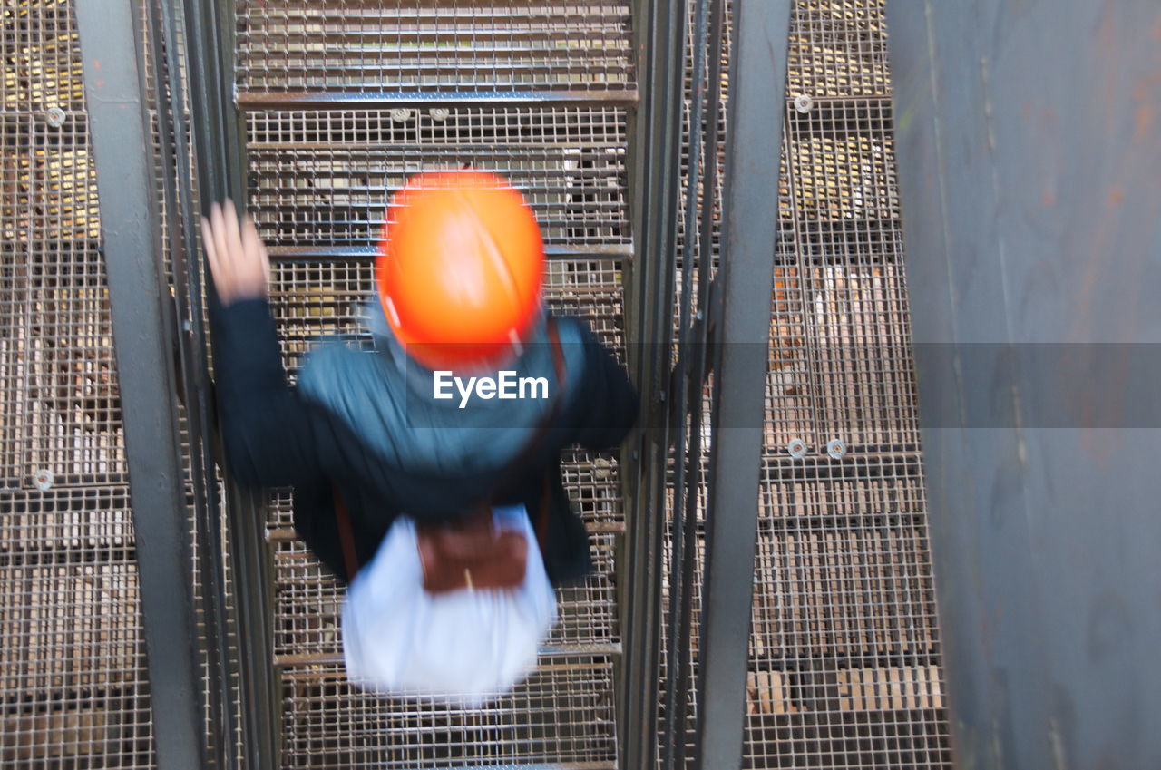 Rear view of person climbing staircase