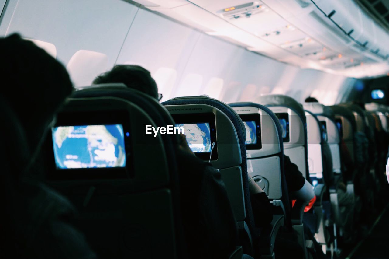 Rear view of people on seats in airplane