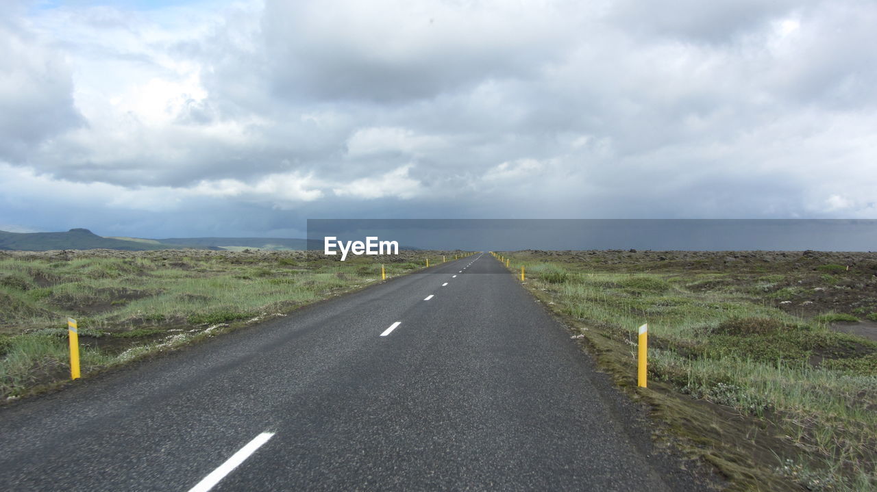 Empty road against storm clouds