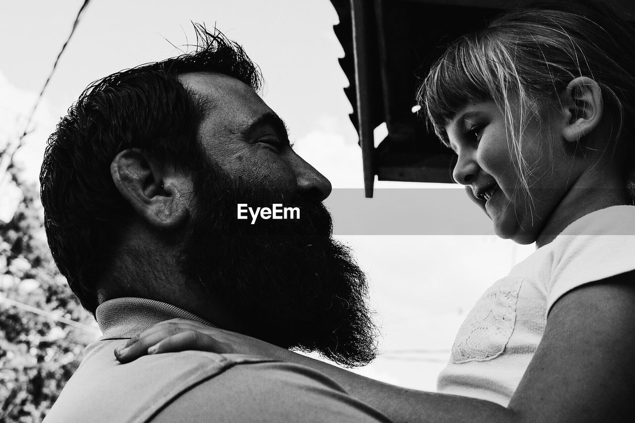 Close-up of happy father and daughter against sky