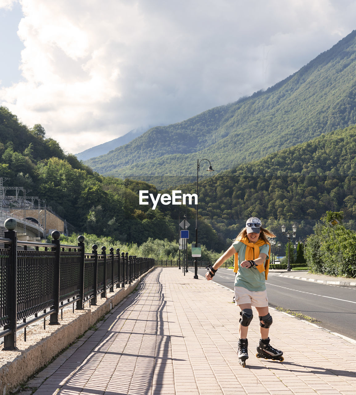 rear view of man walking on road against mountain