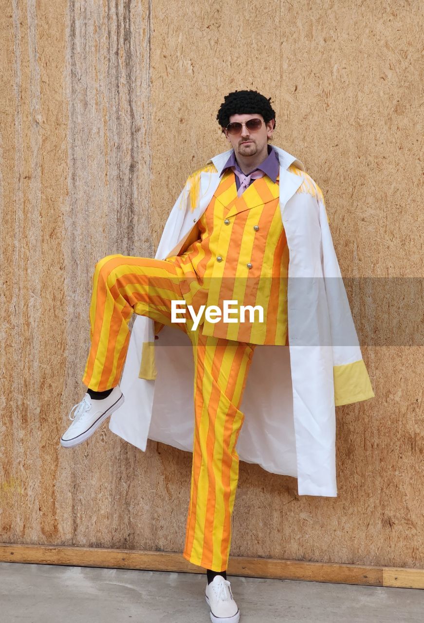 yellow, one person, full length, clothing, adult, men, standing, portrait, fashion, traditional clothing, architecture, front view, young adult, person, glasses, looking at camera, wall - building feature, sunglasses, smiling, spring, costume, tradition, holding