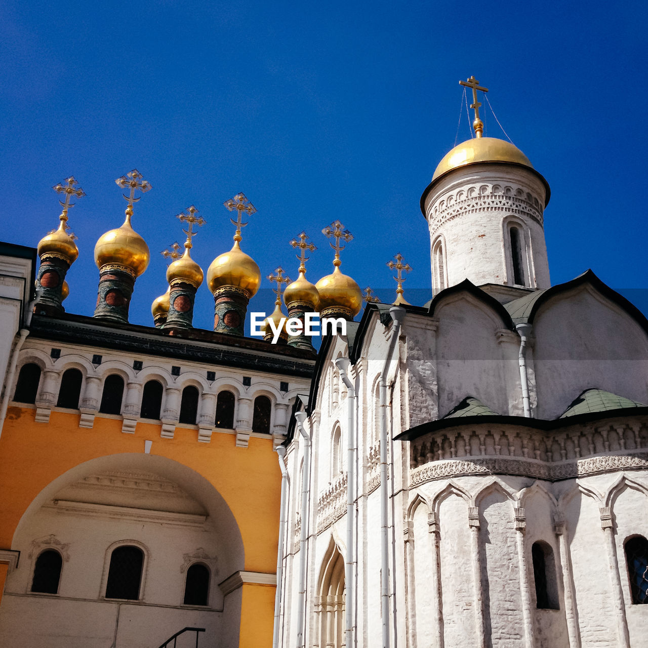 Golden domes of terem churches against clear blue sky