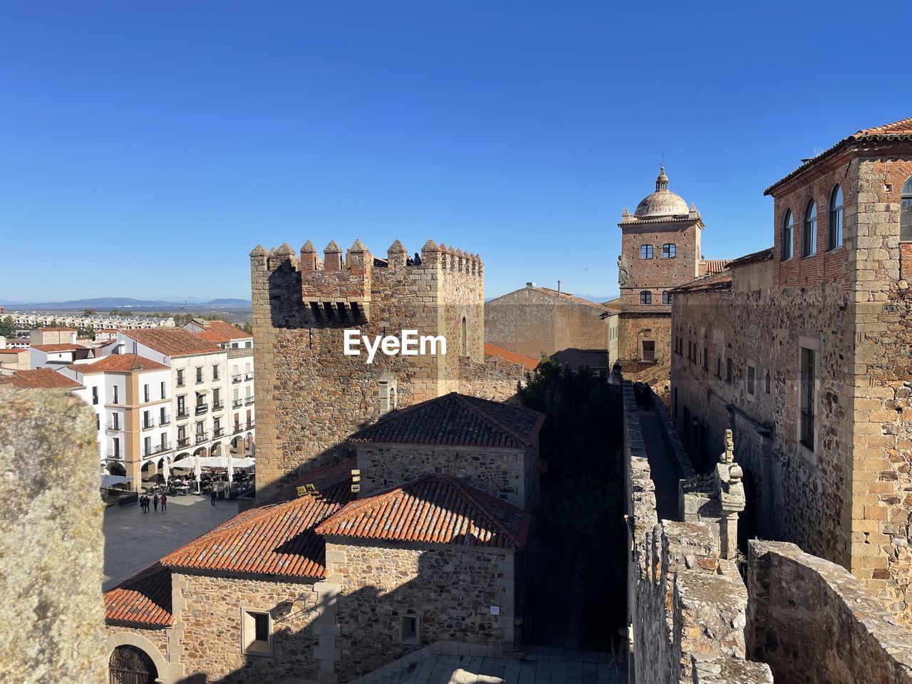 Buildings in city against clear blue sky