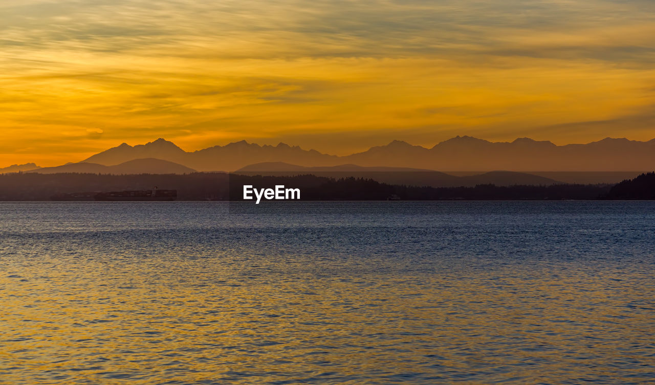 Olympic mountain range across the puget sound at sunset.