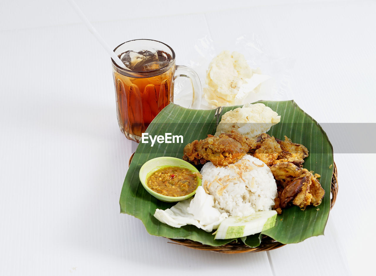 Nasi uduk ayam goreng with ice tea, homemade of famous indonesian cuisine