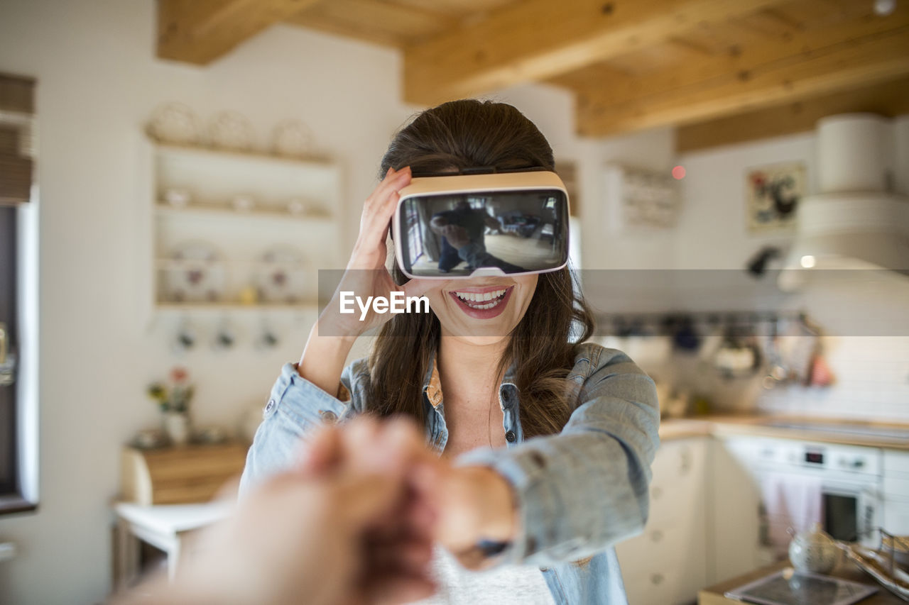 Young woman at home using virtual reality goggles