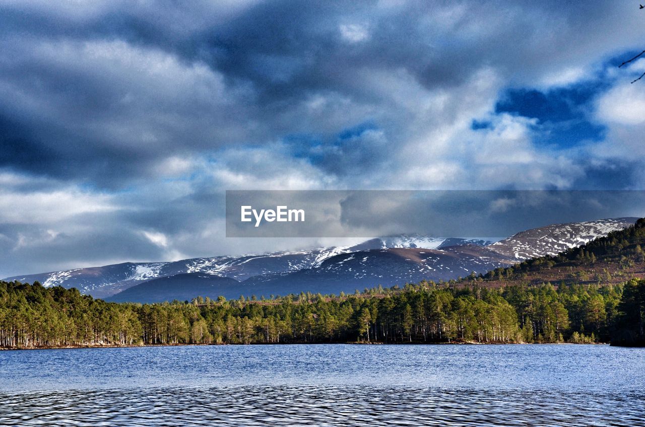 Scenic view of lake by mountains against sky