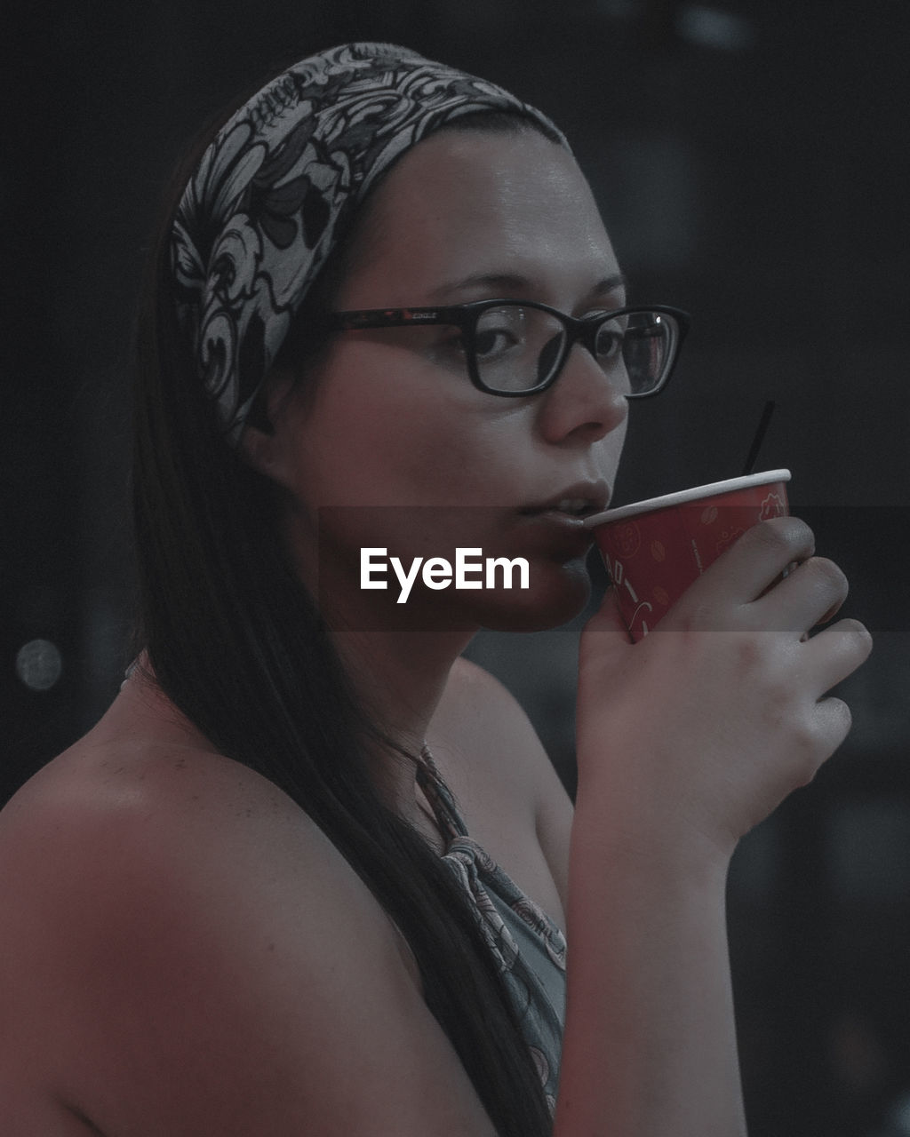 Young woman wearing eyeglasses drinking coffee