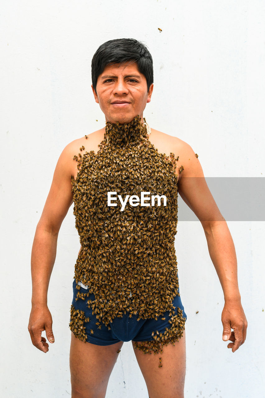 Man covered by many bees