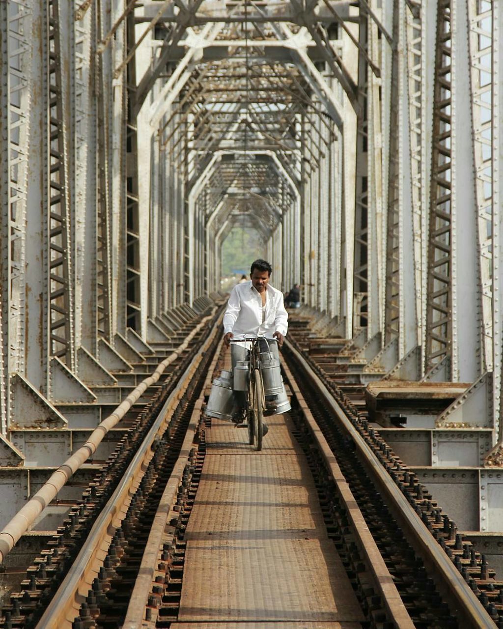 Man riding bike on bridge