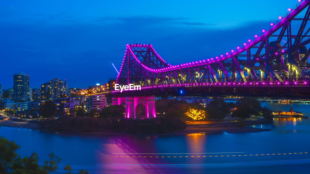 Illuminated suspension bridge over river at night