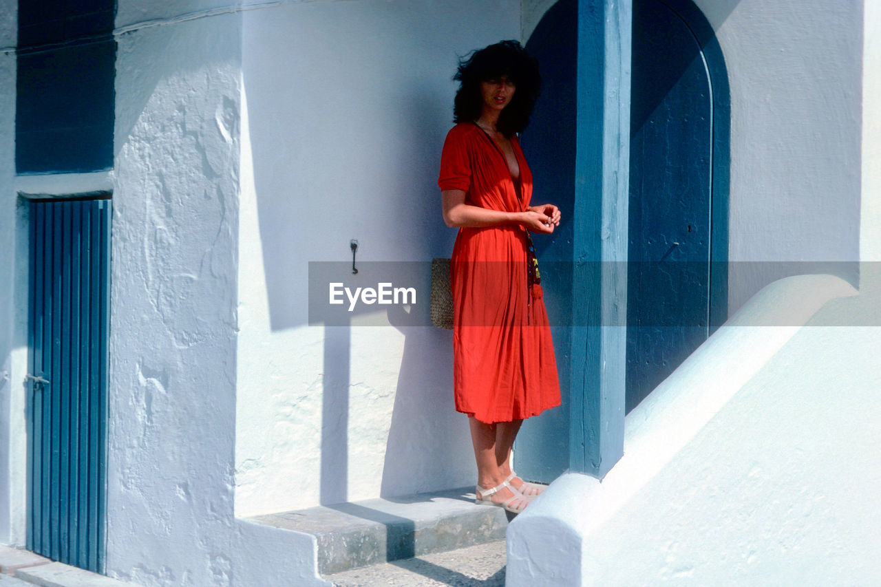 Woman standing against house