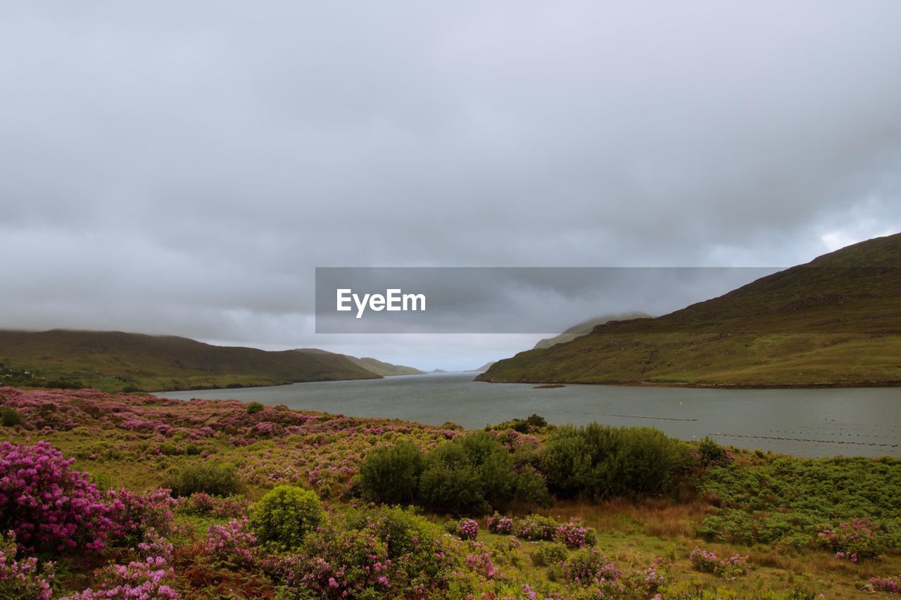 Scenic view of mountains and lake against cloudy sky