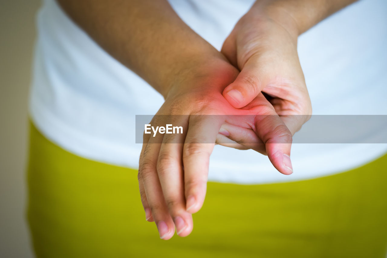 Midsection of woman suffering from pain on hand