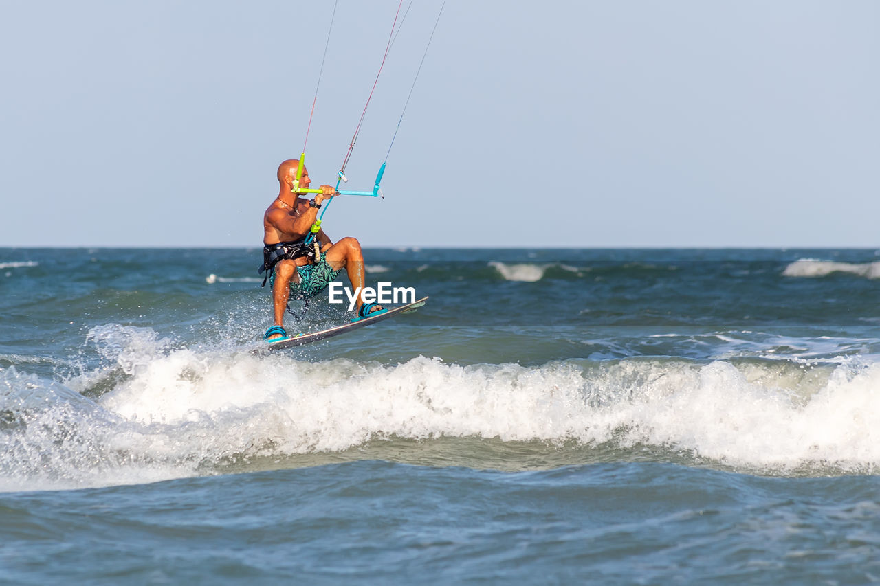 Man surfing in sea against sky