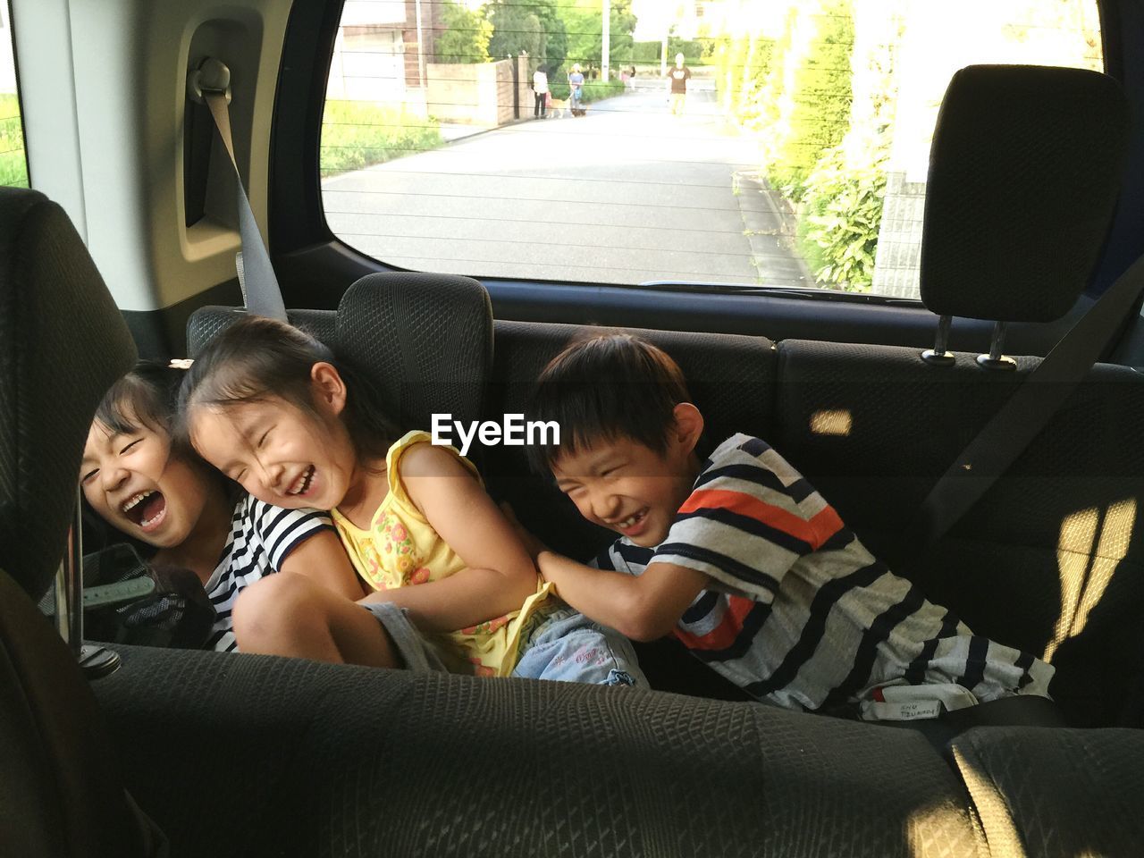 Cheerful siblings enjoying in car