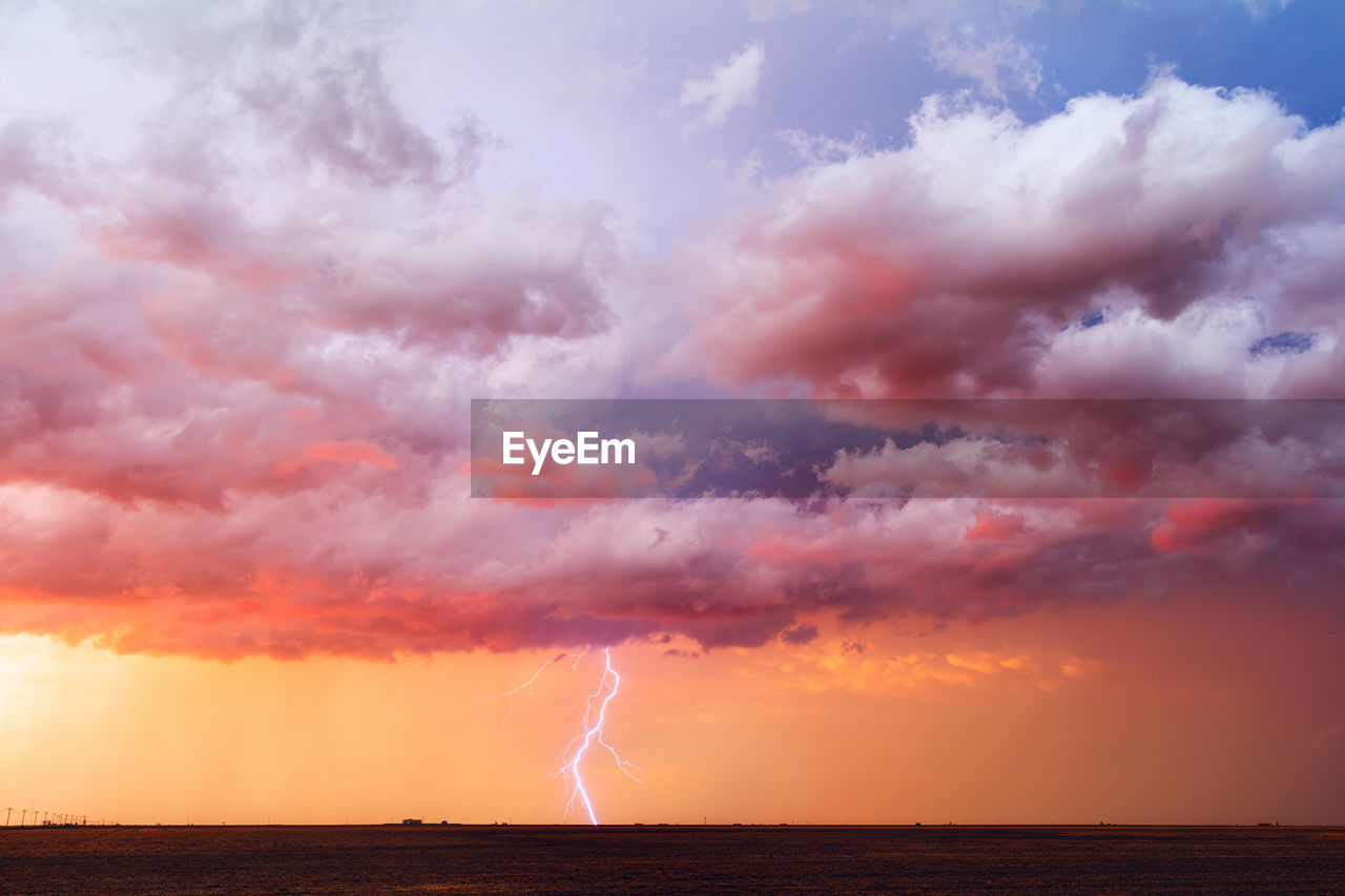 Lightning strikes through a colorful sunset sky near booker, texas.