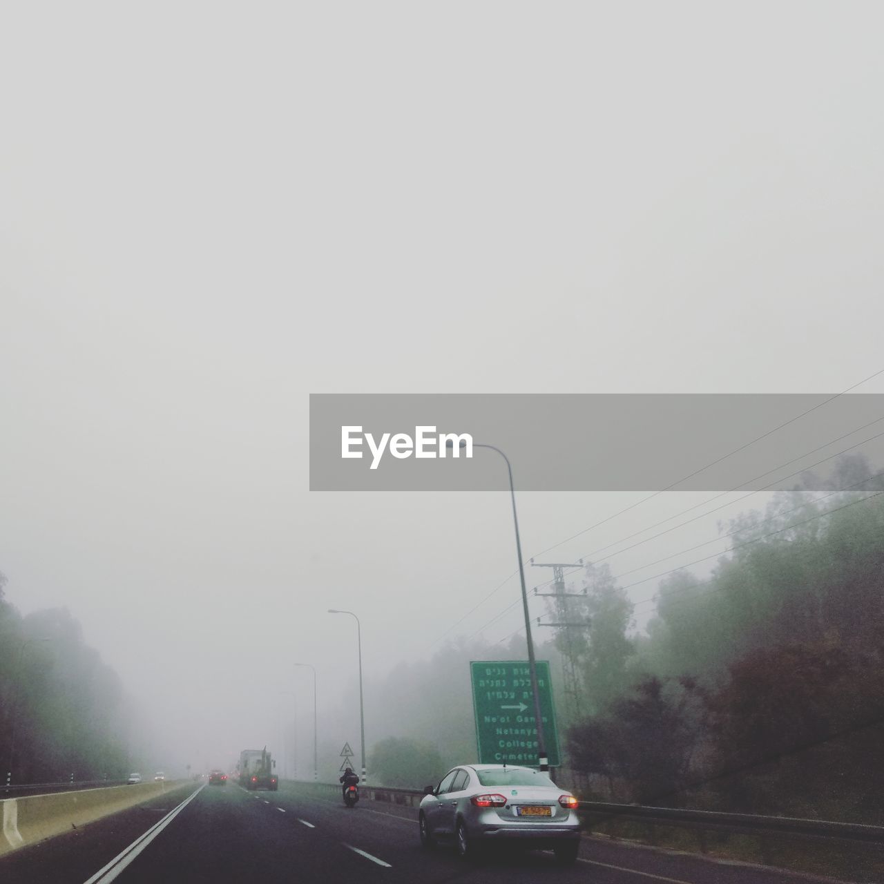 CARS ON ROAD AGAINST SKY IN FOG