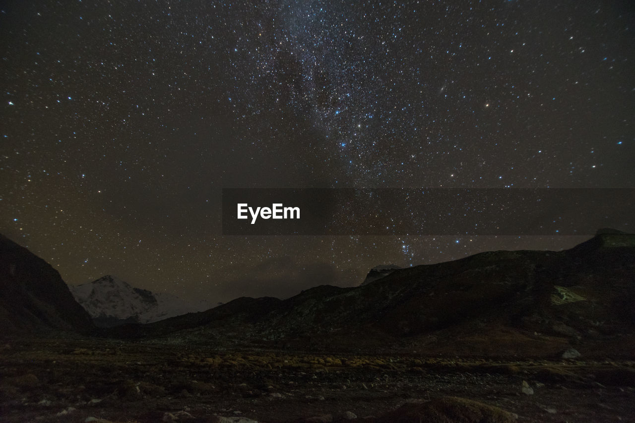 Scenic view of mountains against sky at night