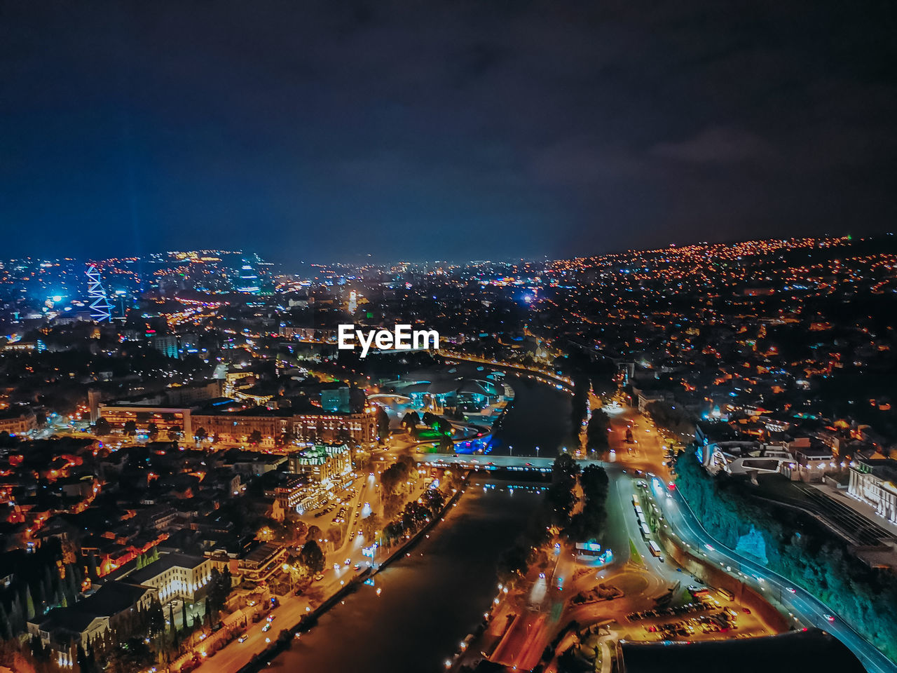 High angle view of illuminated city against sky at night