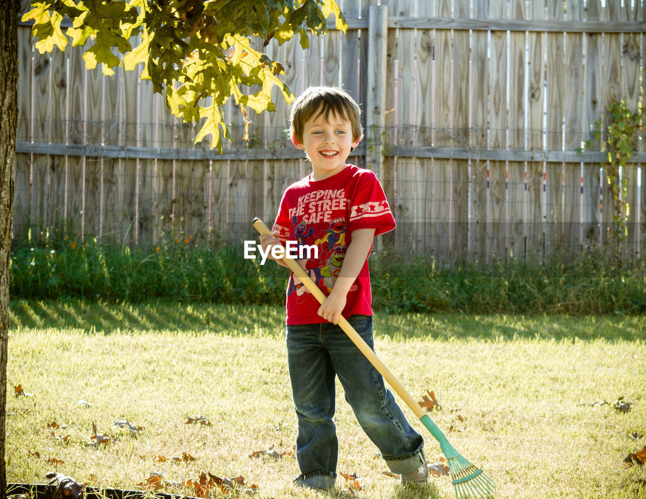 Full length of boy with gardening rake at yard