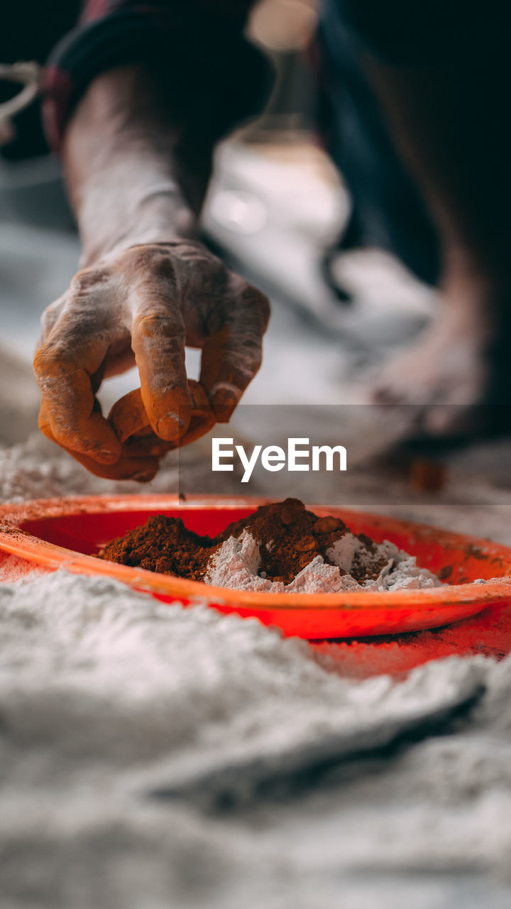 A worker is mixing the color of the concrete.