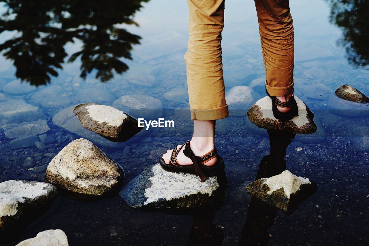 Low section of person on rocks in river