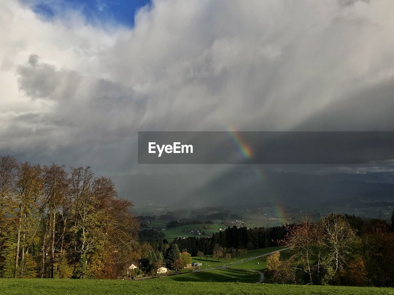 SCENIC VIEW OF RAINBOW OVER LANDSCAPE AGAINST SKY