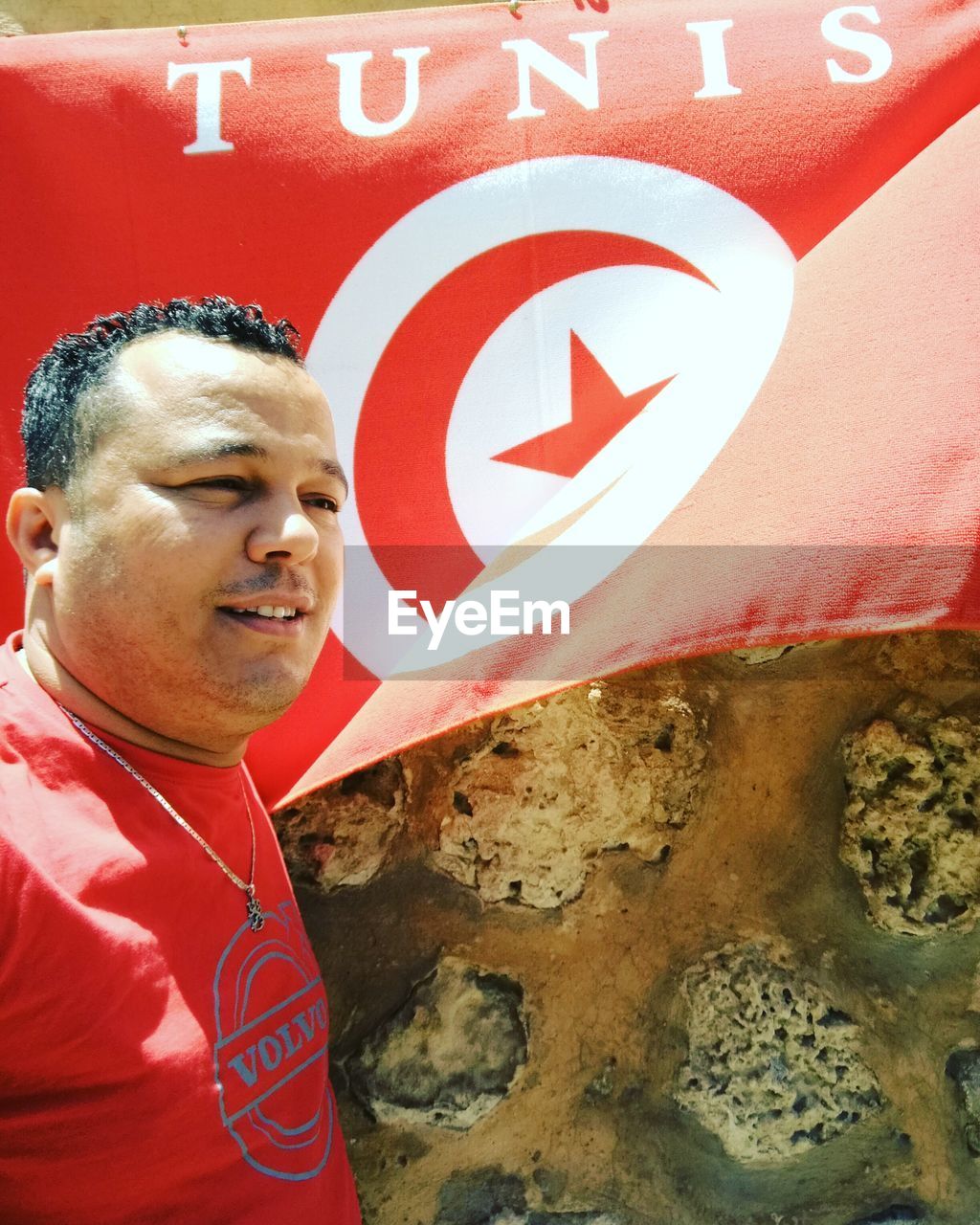 FULL LENGTH OF MAN STANDING BY RED SIGN