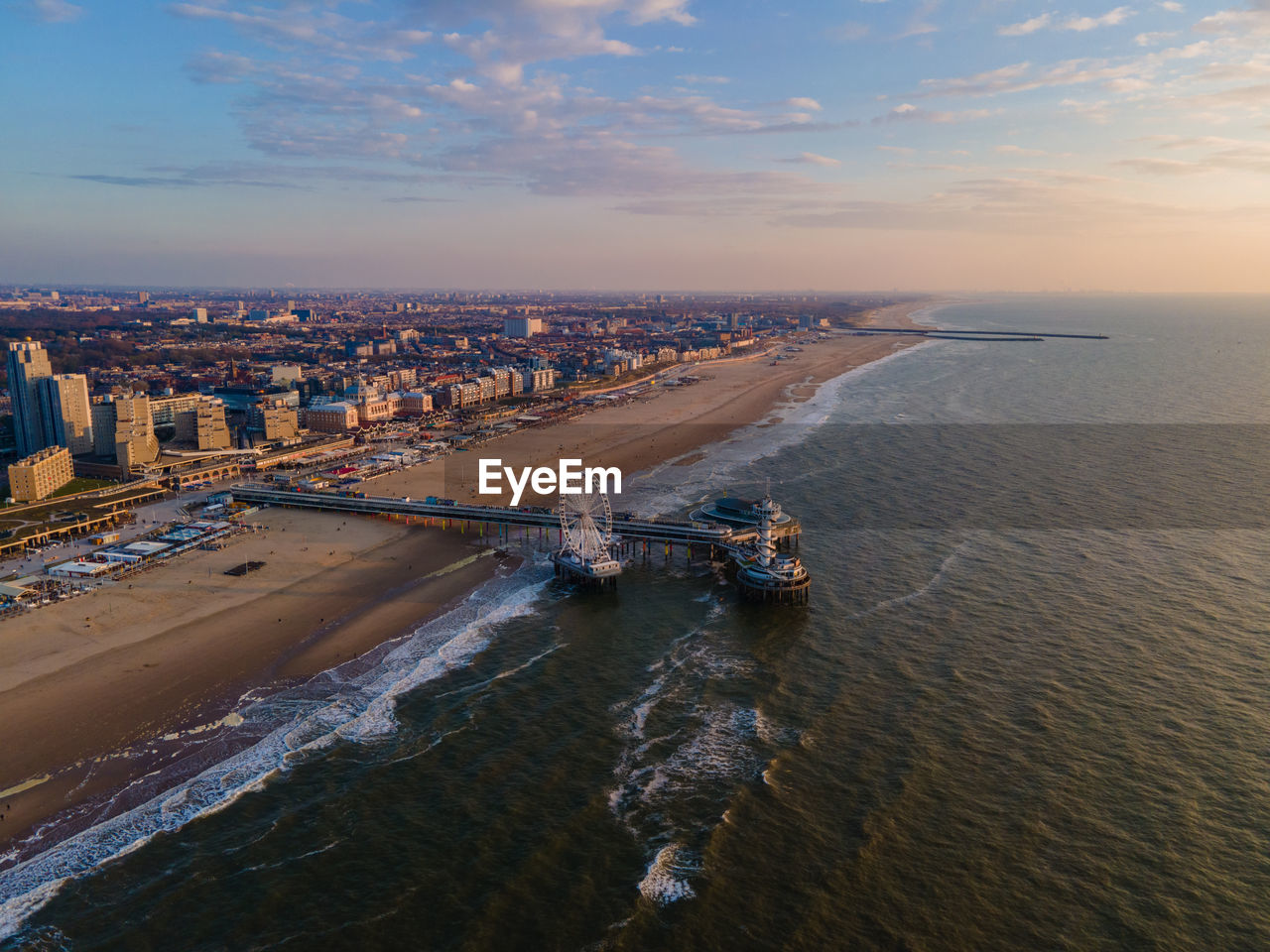 HIGH ANGLE VIEW OF SEA AND CITYSCAPE AGAINST SKY