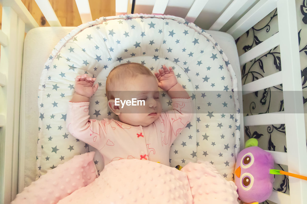 portrait of cute baby boy sleeping on bed