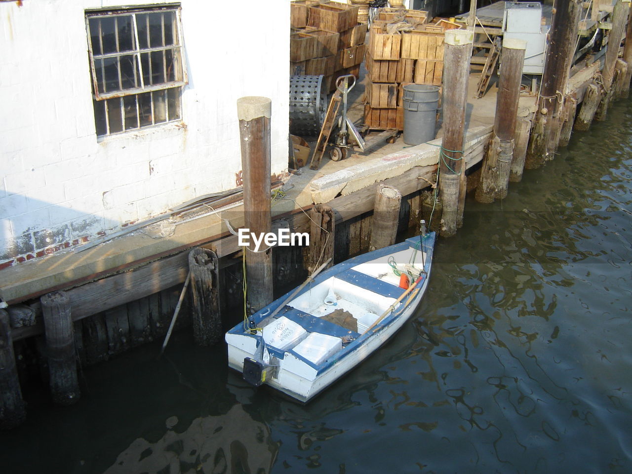 High angle view of boat moored by wooden post at harbor