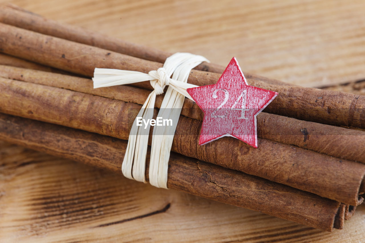 Bundle of cinnamon sticks with star shape tag on table