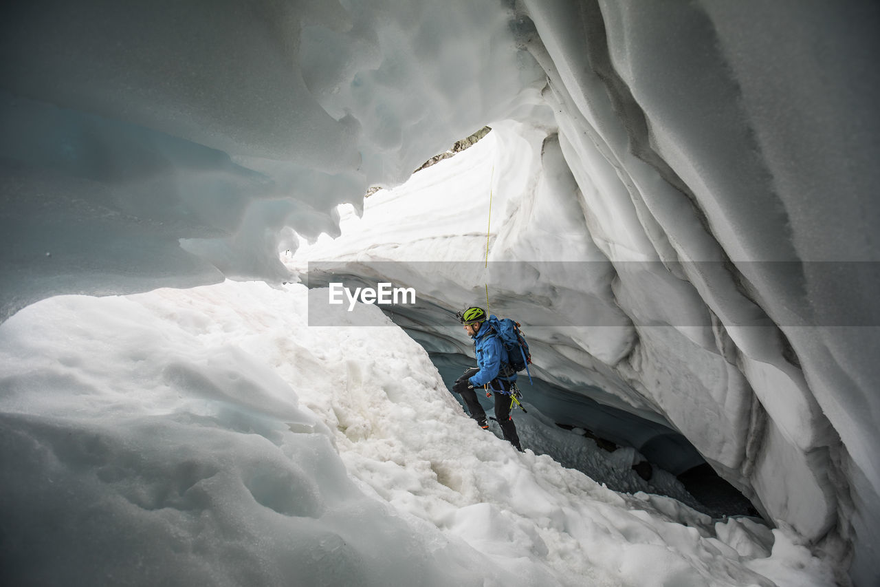 Mountaineer climbs out of glacial cave near, coast mountains, b.c.