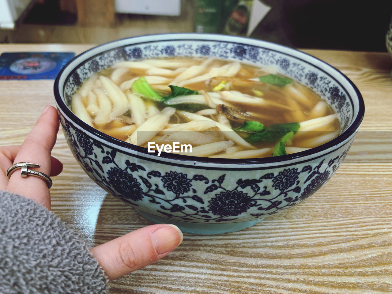 MIDSECTION OF WOMAN HOLDING BOWL OF SOUP